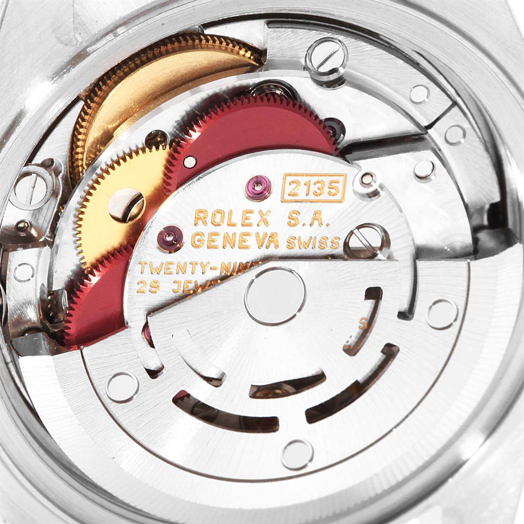 This image shows a close-up of the intricate internal mechanism of a Rolex Datejust 69163 Women's Steel and Gold (two tone) Grey Dial 69163 Women's Steel and Gold (two tone) Grey Dial watch, including gears and engraved details.