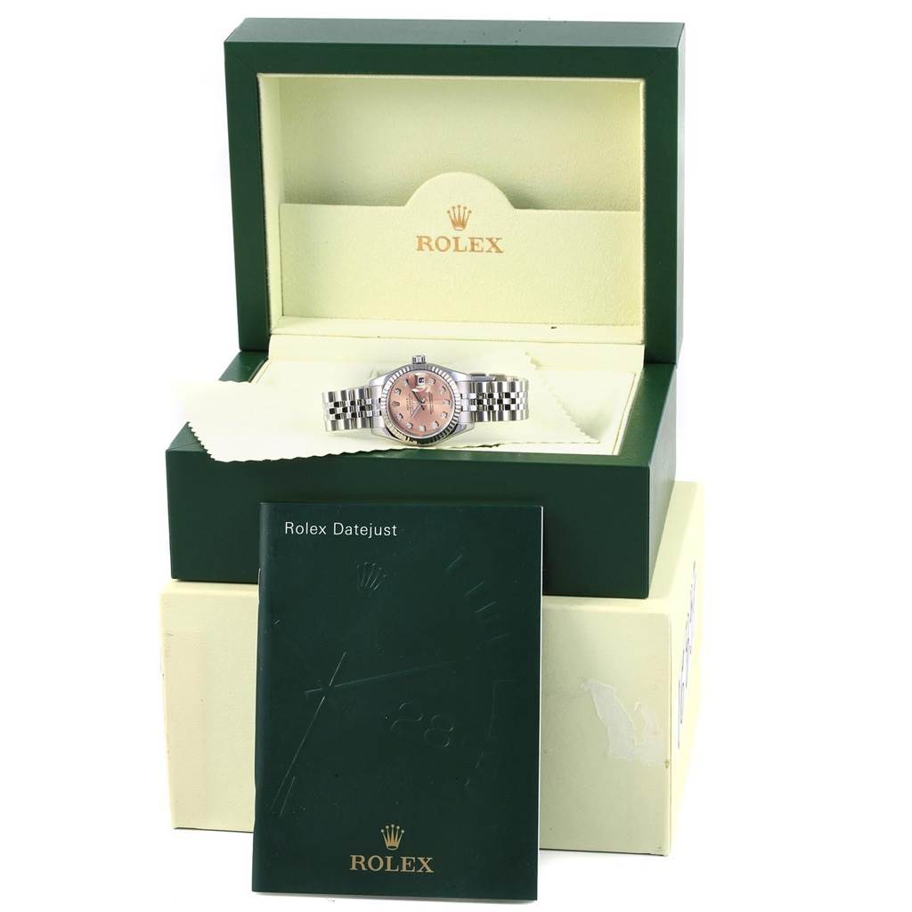 The image shows a Rolex Datejust 179174 Women
s Stainless Steel Pink Dial 179174 Women
s Stainless Steel Pink Dial watch in its open box with a booklet in the foreground.