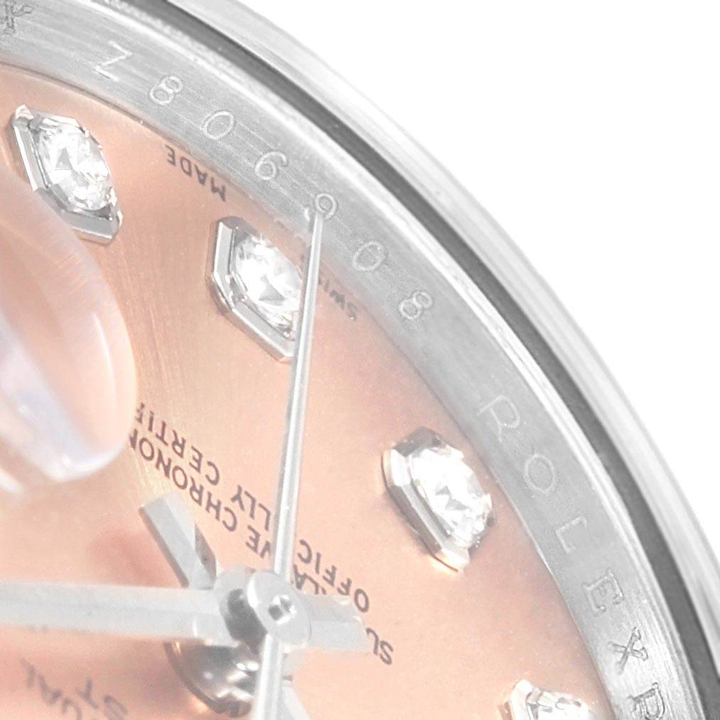 The image shows a close-up of the dial and part of the bezel of a Rolex Datejust 179174 Women
s Stainless Steel Pink Dial 179174 Women
s Stainless Steel Pink Dial, highlighting diamond hour markers and inscription details.