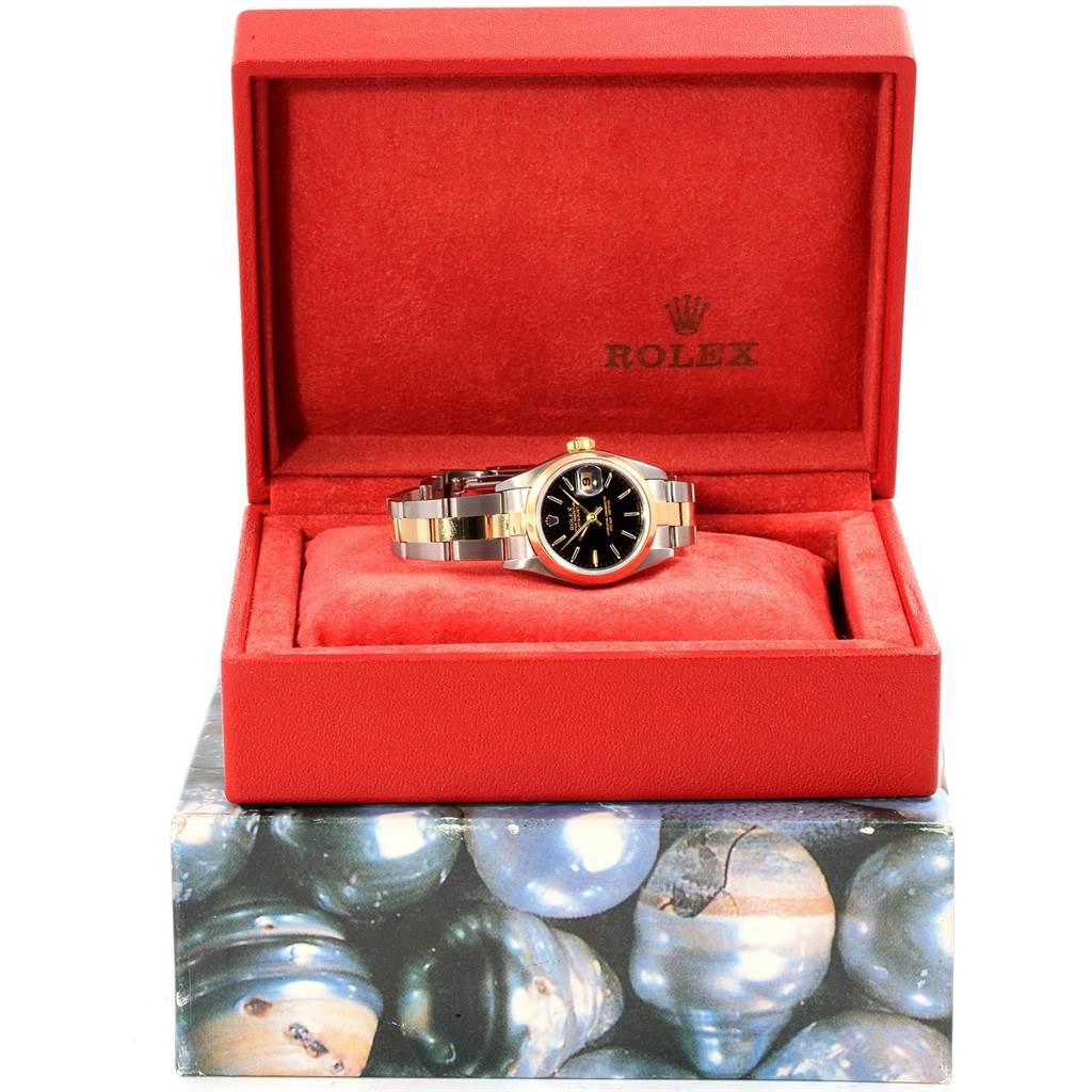 The Rolex Datejust 79163 Women's Steel and Gold (two tone) Black Dial 79163 Women's Steel and Gold (two tone) Black Dial watch is shown at a front angle, displayed inside its red packaging box.