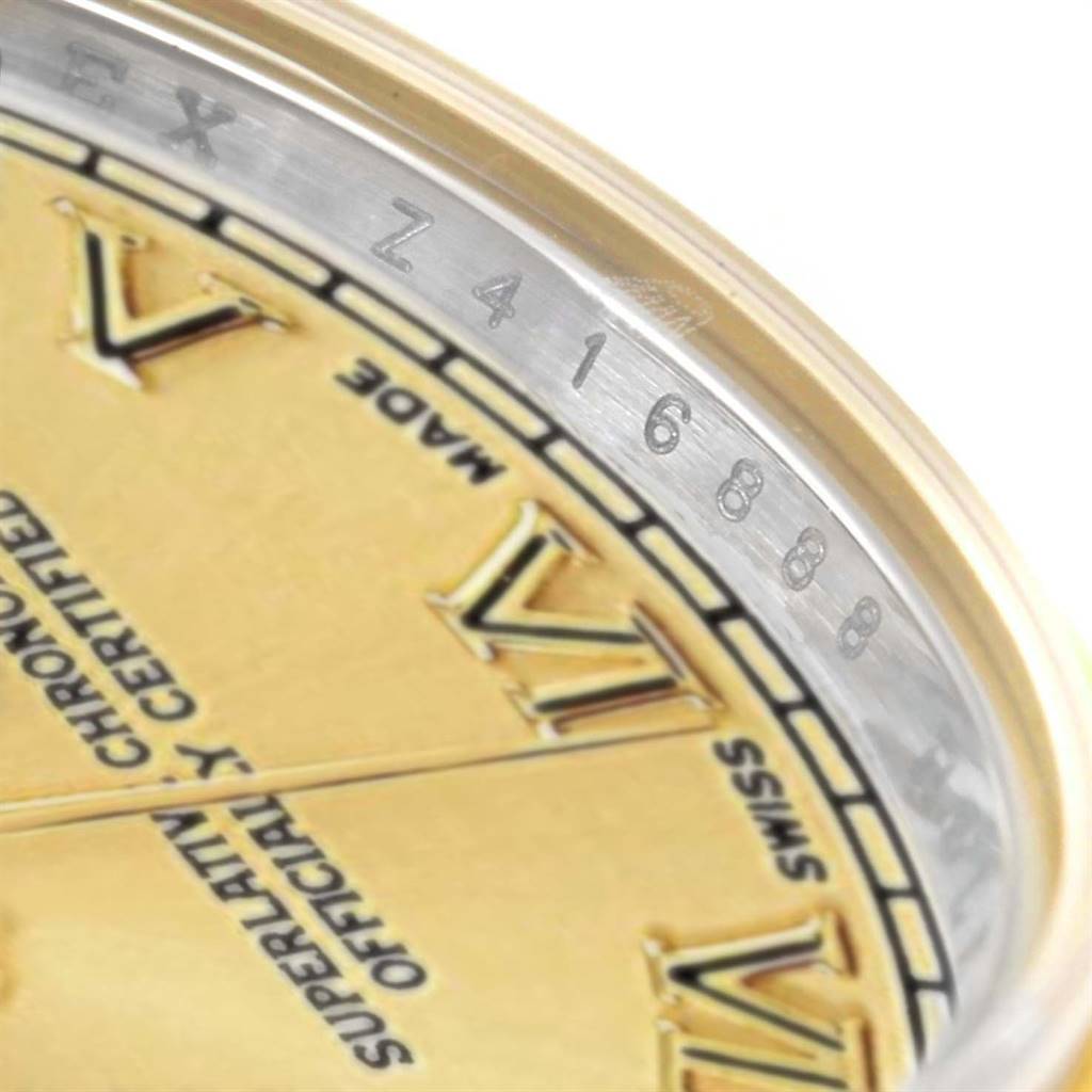 The image shows a close-up of the Rolex Datejust 179173 Women's Steel and Gold (two tone) Champagne Dial 179173 Women's Steel and Gold (two tone) Champagne Dial watch's serial number on the edge of the dial, with part of the golden dial and Roman numerals visible.