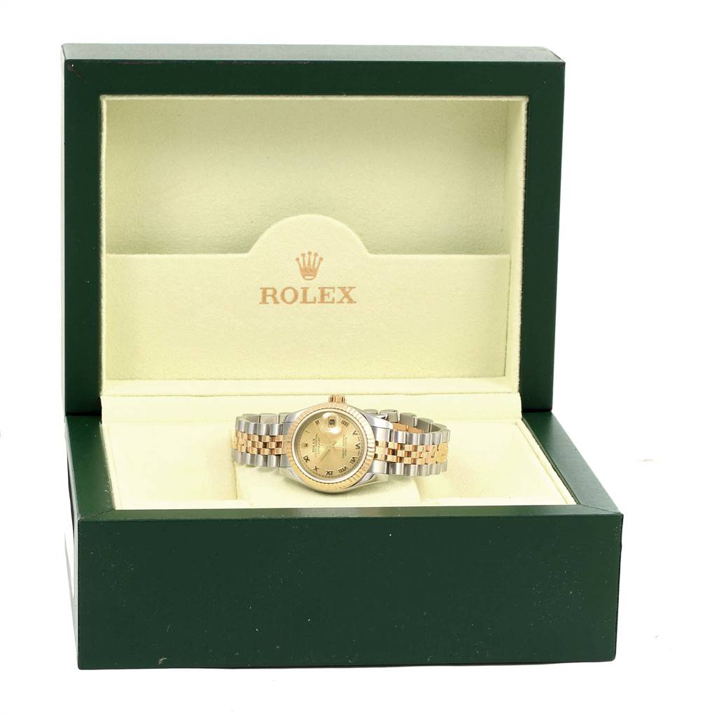 The Rolex Datejust 179173 Women's Steel and Gold (two tone) Champagne Dial 179173 Women's Steel and Gold (two tone) Champagne Dial watch is displayed front-facing inside an open, green box.