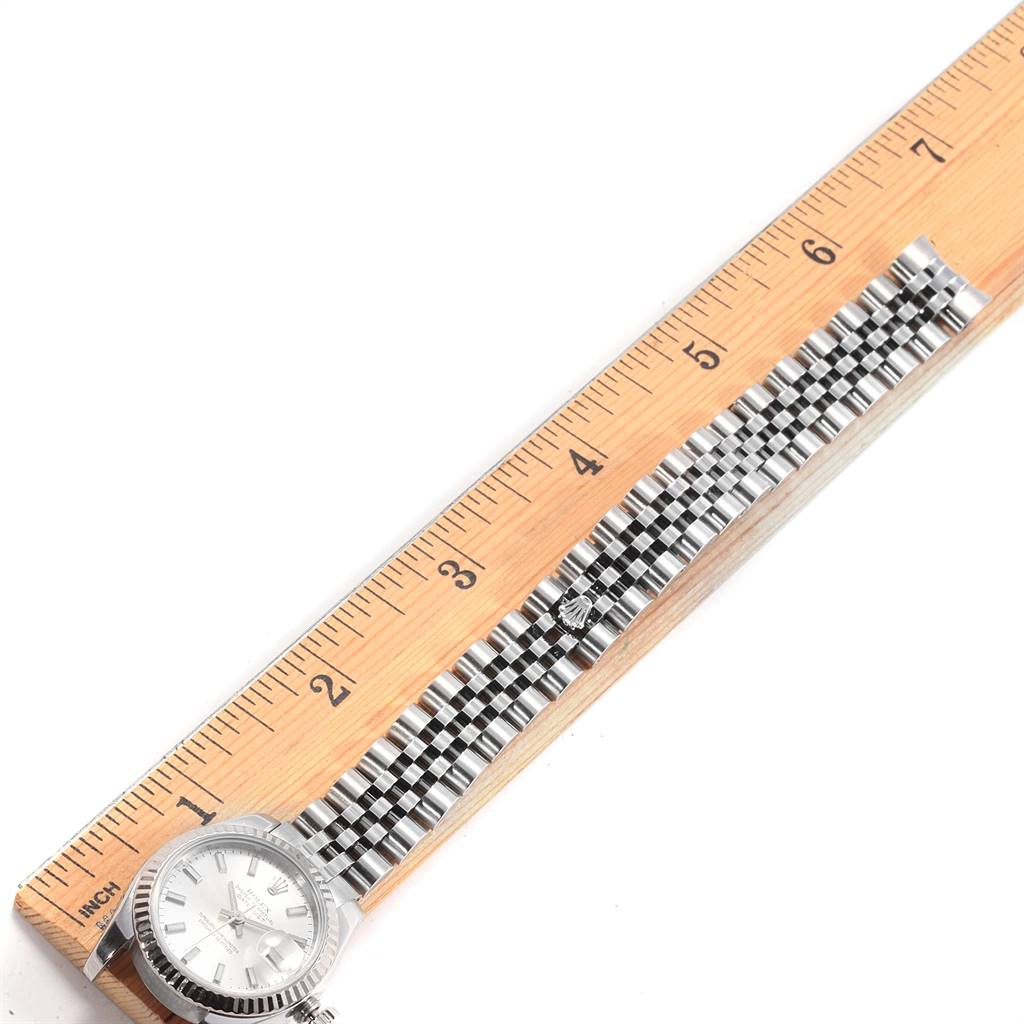 The image shows a Rolex Datejust 179174 Women's Steel and Gold (two tone) Silver Dial 179174 Women's Steel and Gold (two tone) Silver Dial watch laid flat with its band measured against a wooden ruler.