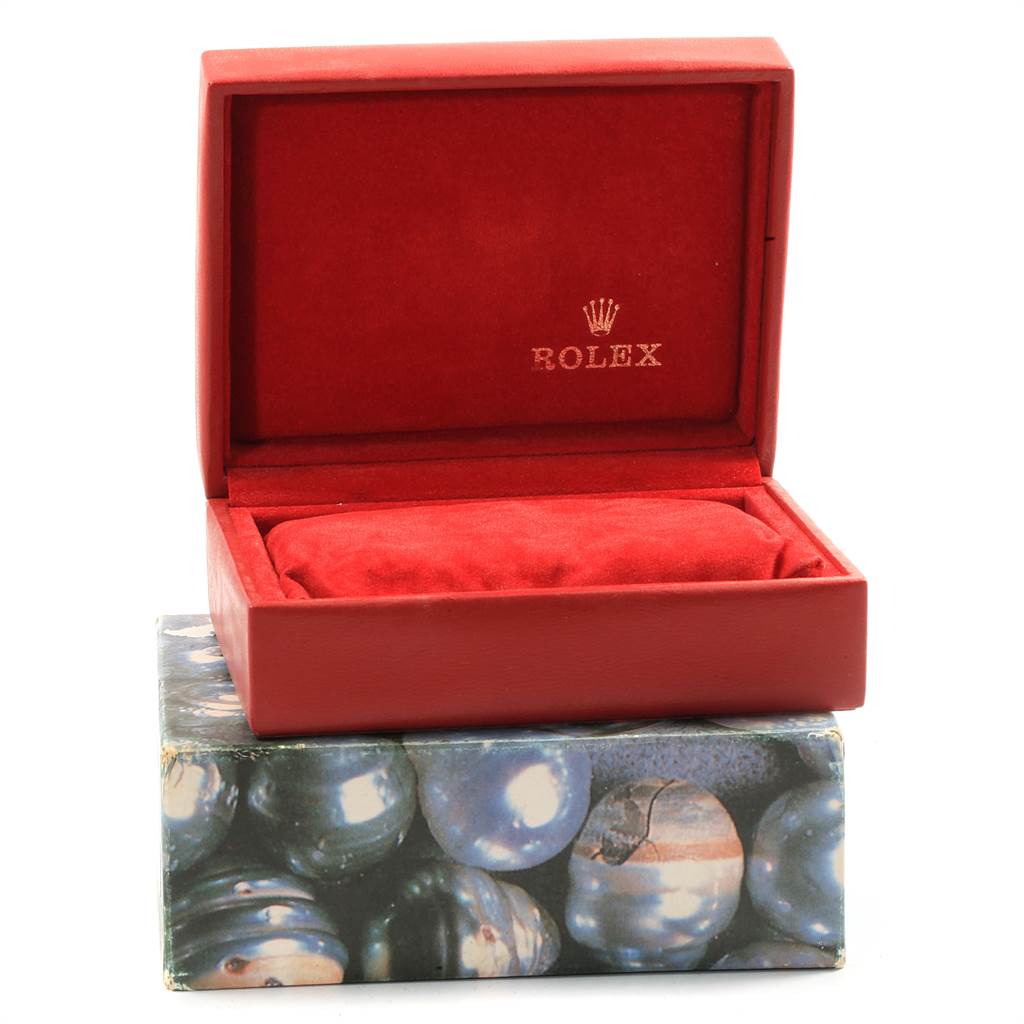 The image shows a red Rolex Datejust 69173 Women
s Stainless Steel Beige Dial 69173 Women
s Stainless Steel Beige Dial watch box with a cushion inside, placed on a decorative external box.