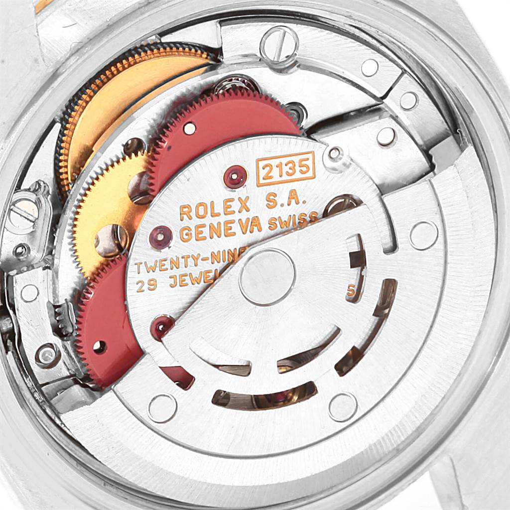 This image shows a close-up of the movement mechanism of a Rolex Datejust 69173 Women
s Stainless Steel Beige Dial 69173 Women
s Stainless Steel Beige Dial watch, featuring gears and the rotor.