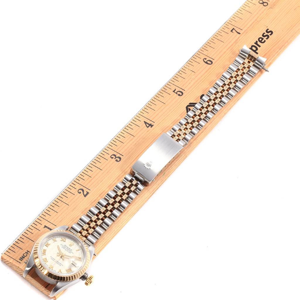 The Rolex Datejust 69173 Women's Stainless Steel Beige Dial 69173 Women's Stainless Steel Beige Dial watch is displayed fully extended beside a ruler, showing its face, metal bracelet, and clasp.