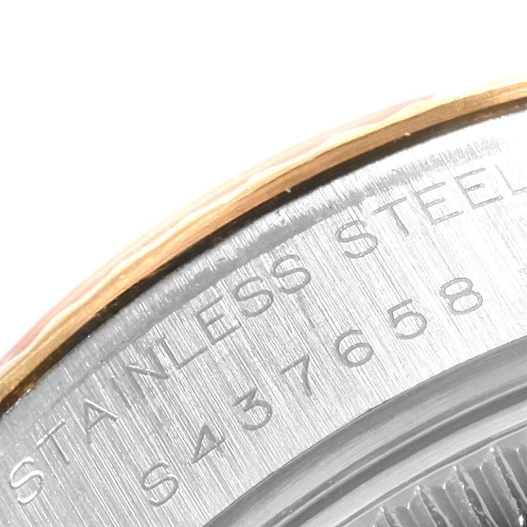 This image shows a close-up of the stainless steel edge and part of the engraved text on the back of a Rolex Datejust 69173 Women's Stainless Steel Beige Dial 69173 Women's Stainless Steel Beige Dial watch.