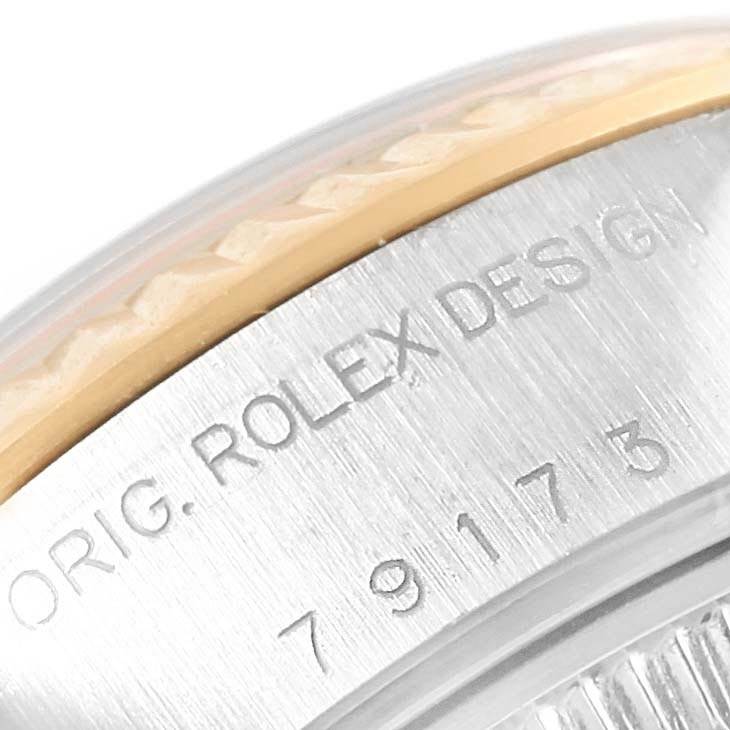 The image shows a close-up of the bezel and part of the case of a Rolex Datejust 79173 Women's Steel and Gold (two tone) White Dial 79173 Women's Steel and Gold (two tone) White Dial watch, highlighting the engraving "ORIG. ROLEX DESIGN."