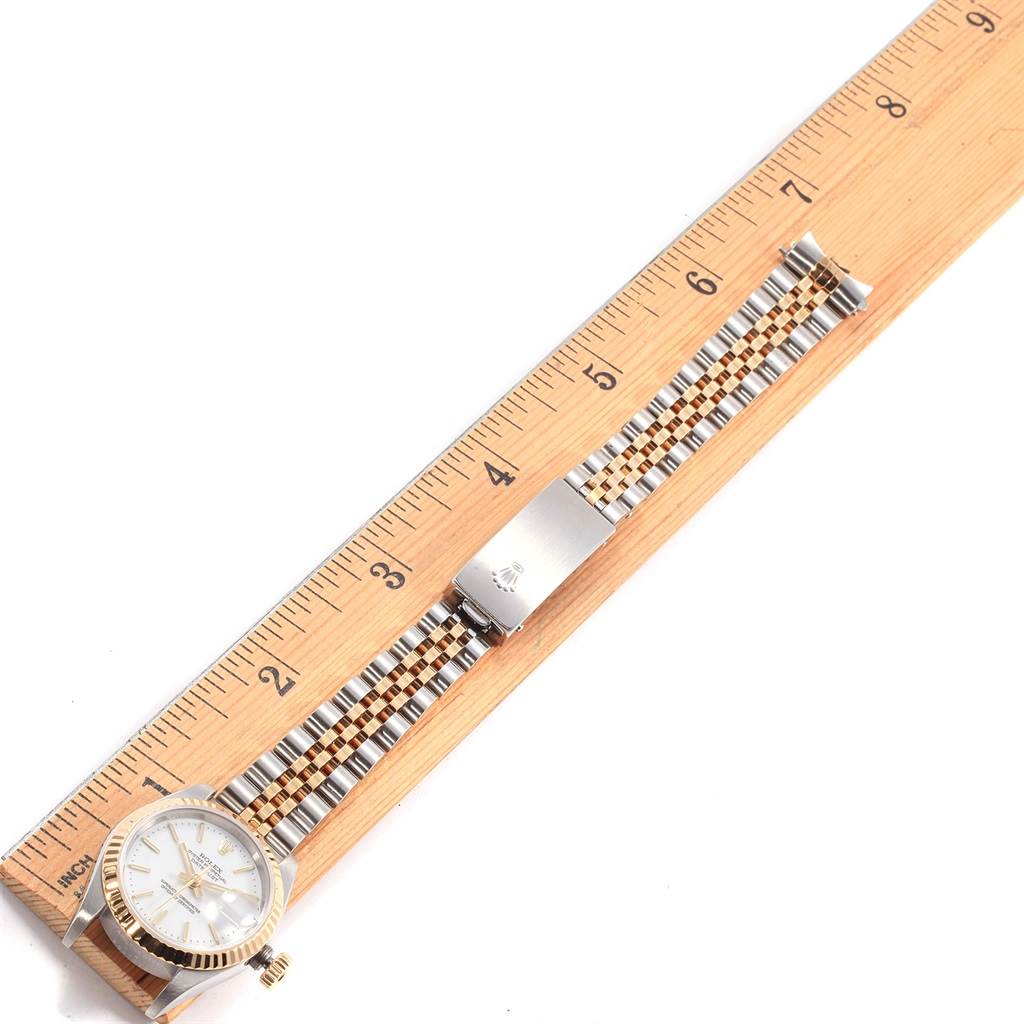 The image shows the Rolex Datejust 79173 Women's Steel and Gold (two tone) White Dial 79173 Women's Steel and Gold (two tone) White Dial watch laid flat alongside a ruler, displaying the face, crown, and entire band.