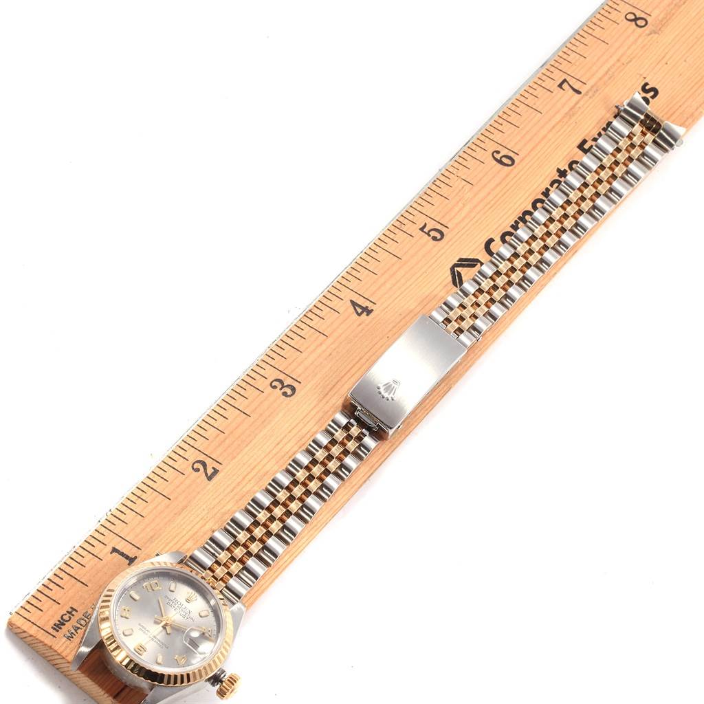 This image shows a Rolex Datejust 79173 Women's Steel and Gold (two tone) Grey Dial 79173 Women's Steel and Gold (two tone) Grey Dial watch laid flat next to a ruler, displaying its dial, bezel, bracelet, and clasp.