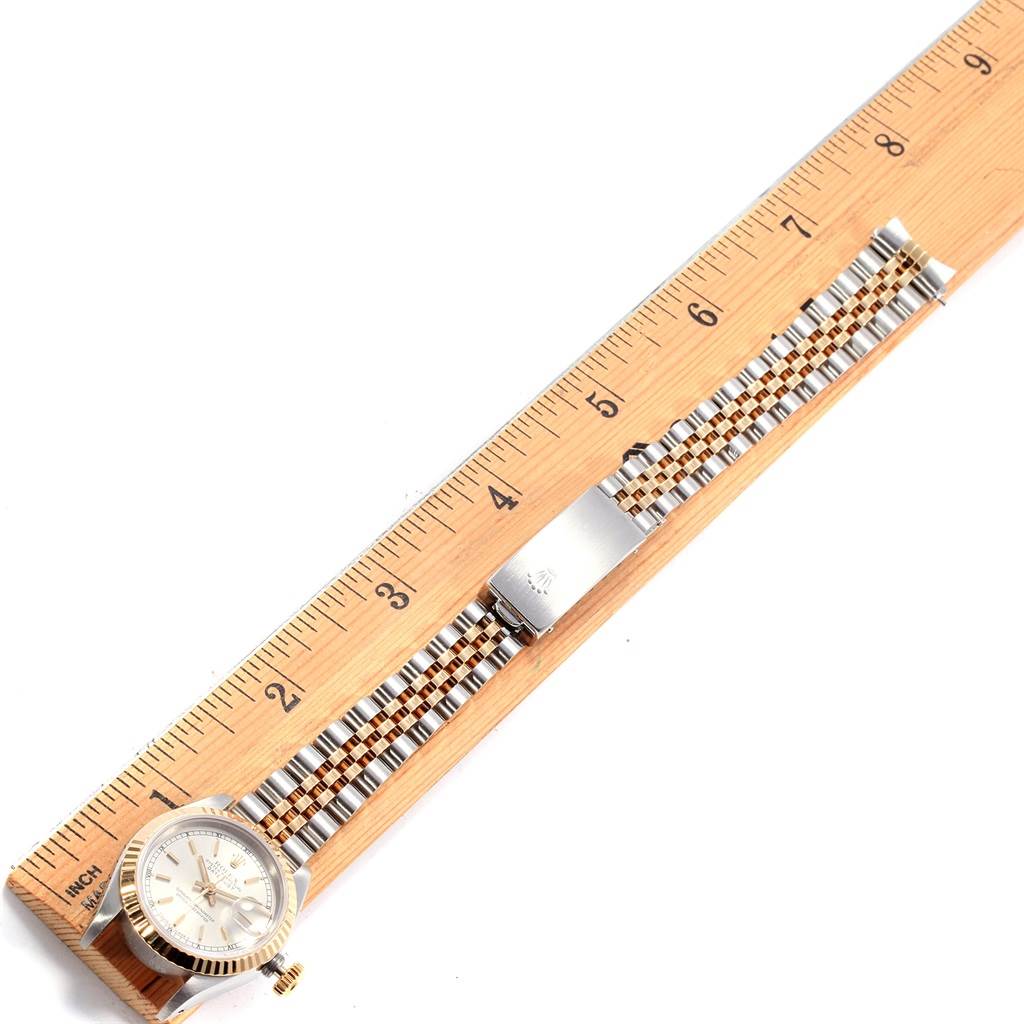 The image shows a Rolex Datejust 69173 Women's Stainless Steel Silver Dial 69173 Women's Stainless Steel Silver Dial watch placed beside a ruler, highlighting its two-tone metal band and bezel.