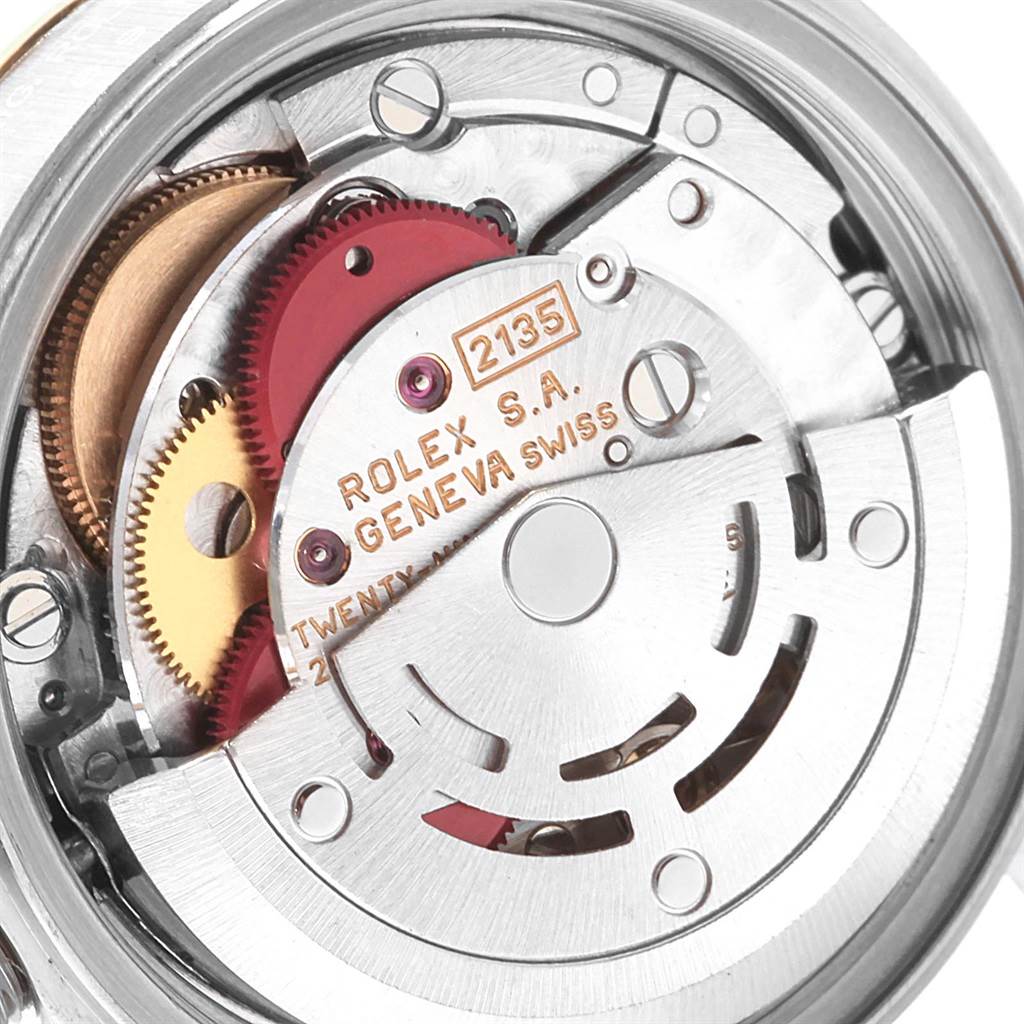 The image shows the intricate internal mechanism of a Rolex Datejust 69173 Women's Stainless Steel Beige Dial 69173 Women's Stainless Steel Beige Dial watch, highlighting gears and the rotor.