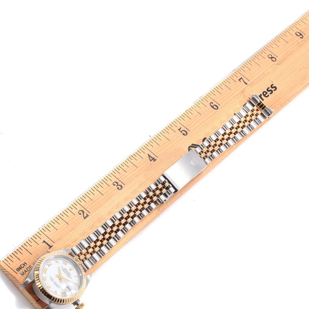 The Rolex Datejust 79173 Women's Steel and Gold (two tone) White Dial 79173 Women's Steel and Gold (two tone) White Dial watch is shown from the front, with a close-up on its face and two-tone bracelet measured against a ruler.