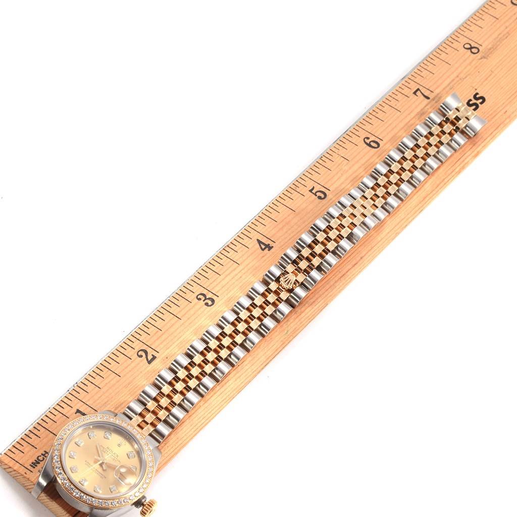 The Rolex Datejust 179383 Women's Steel and Gold (two tone) Champagne Dial 179383 Women's Steel and Gold (two tone) Champagne Dial watch is shown with its face and bracelet laid next to a ruler, providing a top-down view.