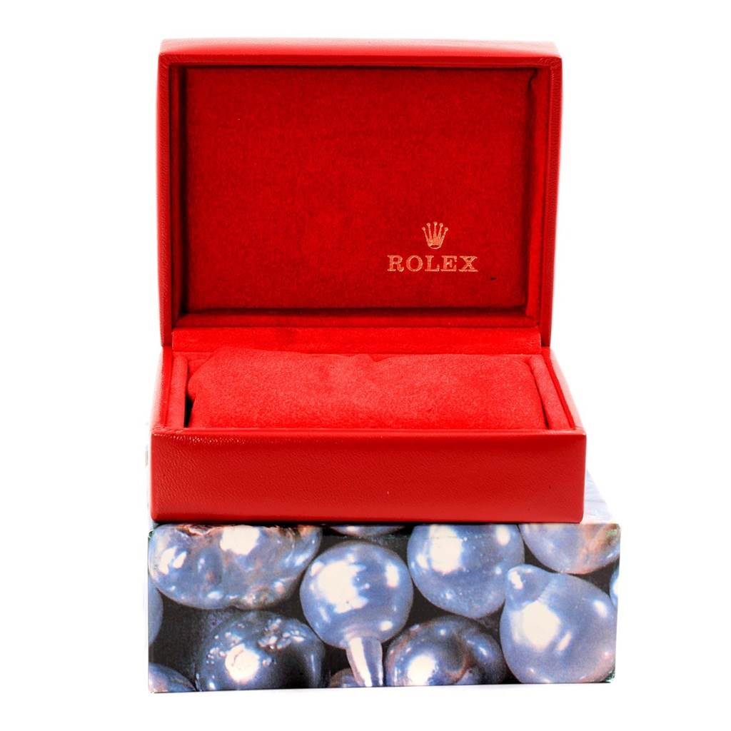 The image shows a red Rolex watch box for the Datejust model, with a partially visible cushion inside.