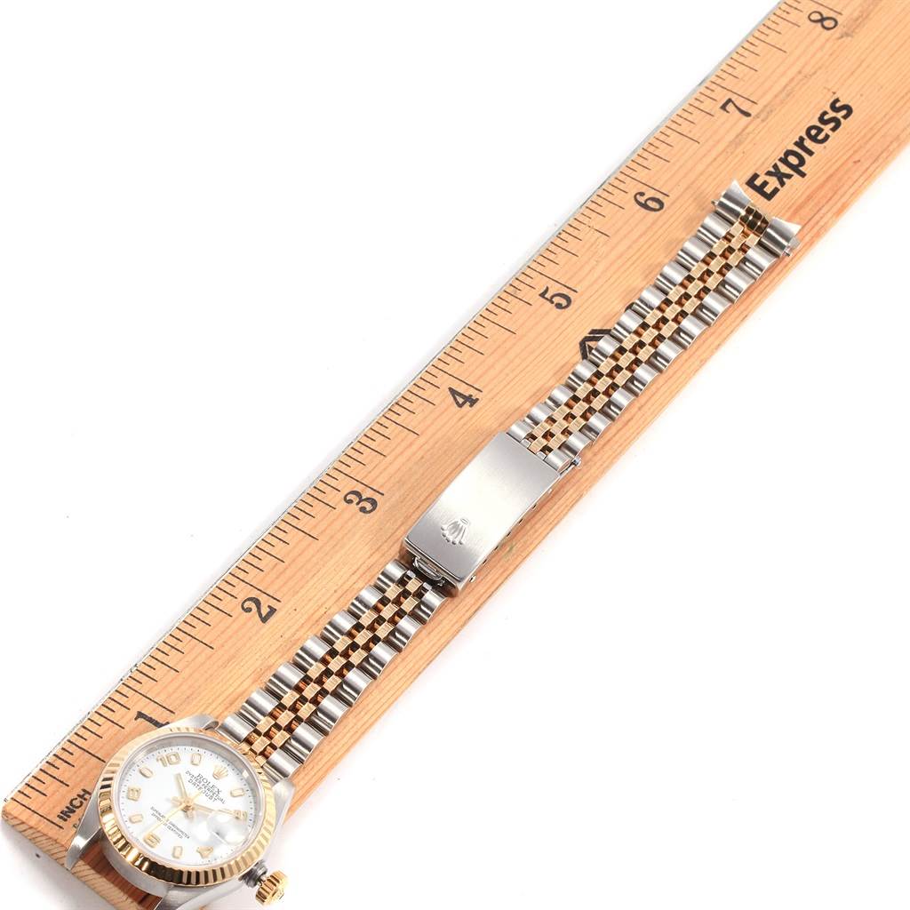 This image shows a Rolex Datejust 69173 Women's Stainless Steel White Dial 69173 Women's Stainless Steel White Dial watch with a two-tone Jubilee bracelet laid next to a ruler for scale.