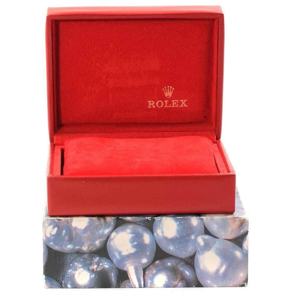 The image shows an open red Rolex watch box for a Datejust model, with a cushion inside.