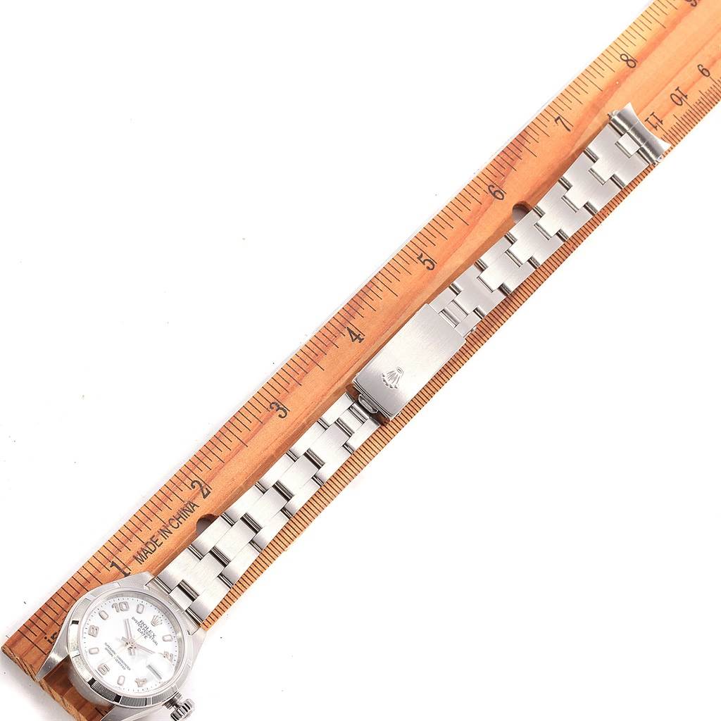 The Rolex Datejust 79190 Women's Stainless Steel White Dial 79190 Women's Stainless Steel White Dial watch is shown from a top-down angle, including the face, bracelet, and clasp, next to a ruler for scale.