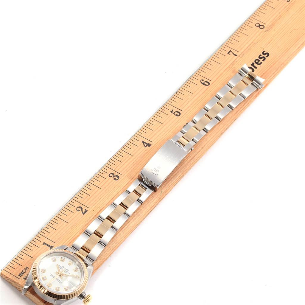 This image shows a Rolex Datejust 69173 Women's Stainless Steel White Dial 69173 Women's Stainless Steel White Dial watch positioned next to a ruler, highlighting its face, band, and clasp.