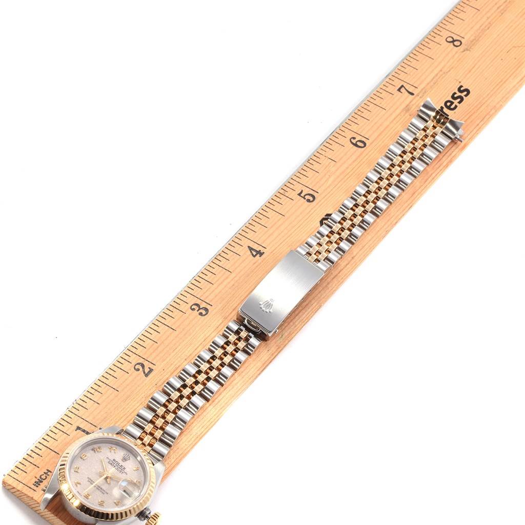 The image shows a top-down view of a Rolex Datejust 69173 Women
s Stainless Steel Beige Dial 69173 Women
s Stainless Steel Beige Dial watch laid next to a ruler, prominently displaying its face and bracelet.