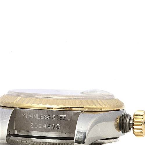 The image shows a side view of a Rolex Datejust 179173 Women's Stainless Steel White Dial 179173 Women's Stainless Steel White Dial watch, highlighting the crown, bezel, and part of the casing with its serial number engraved.