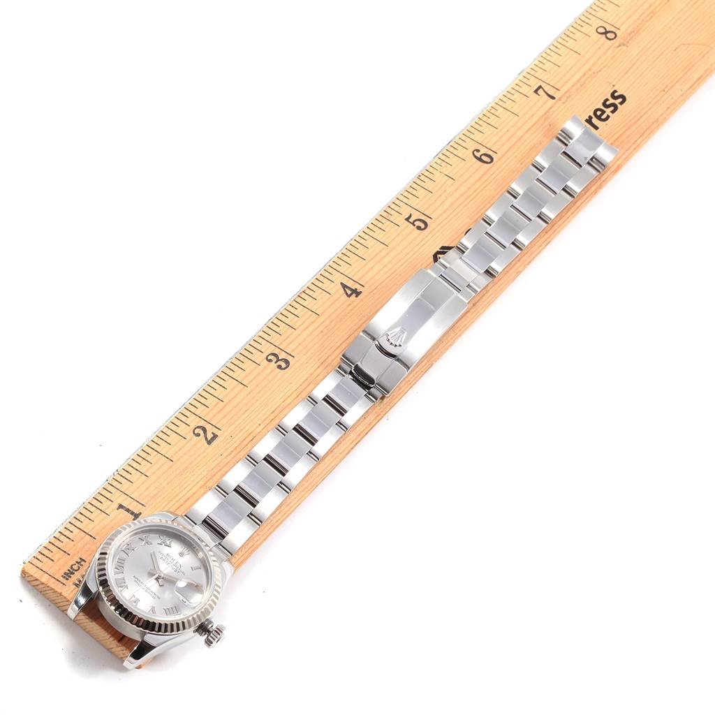 The Rolex Datejust 179174 Women's Stainless Steel Silver Dial 179174 Women's Stainless Steel Silver Dial watch is shown from a top view, resting next to a ruler that measures its length.