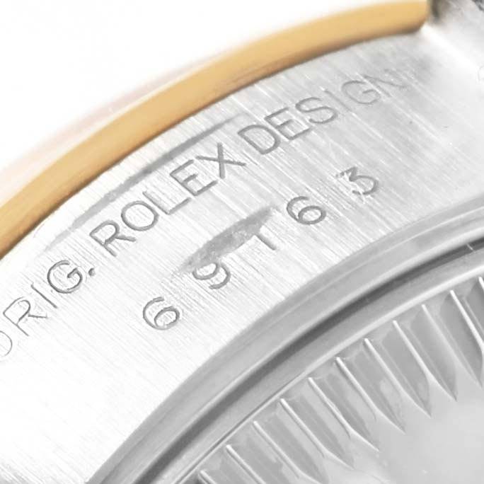 This image shows a close-up of the side of a Rolex Datejust 69163 Women's Steel and Gold (two tone) White Dial 69163 Women's Steel and Gold (two tone) White Dial watch's case with part of the serial number and "ROLEX DESIGN" visible.