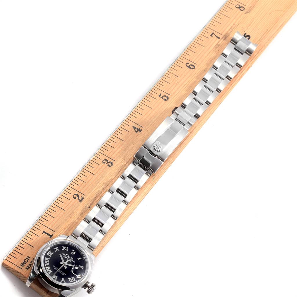 The image shows the Rolex Datejust 179160 Women's Stainless Steel Black Dial 179160 Women's Stainless Steel Black Dial watch laid flat with its bracelet extended alongside a ruler.