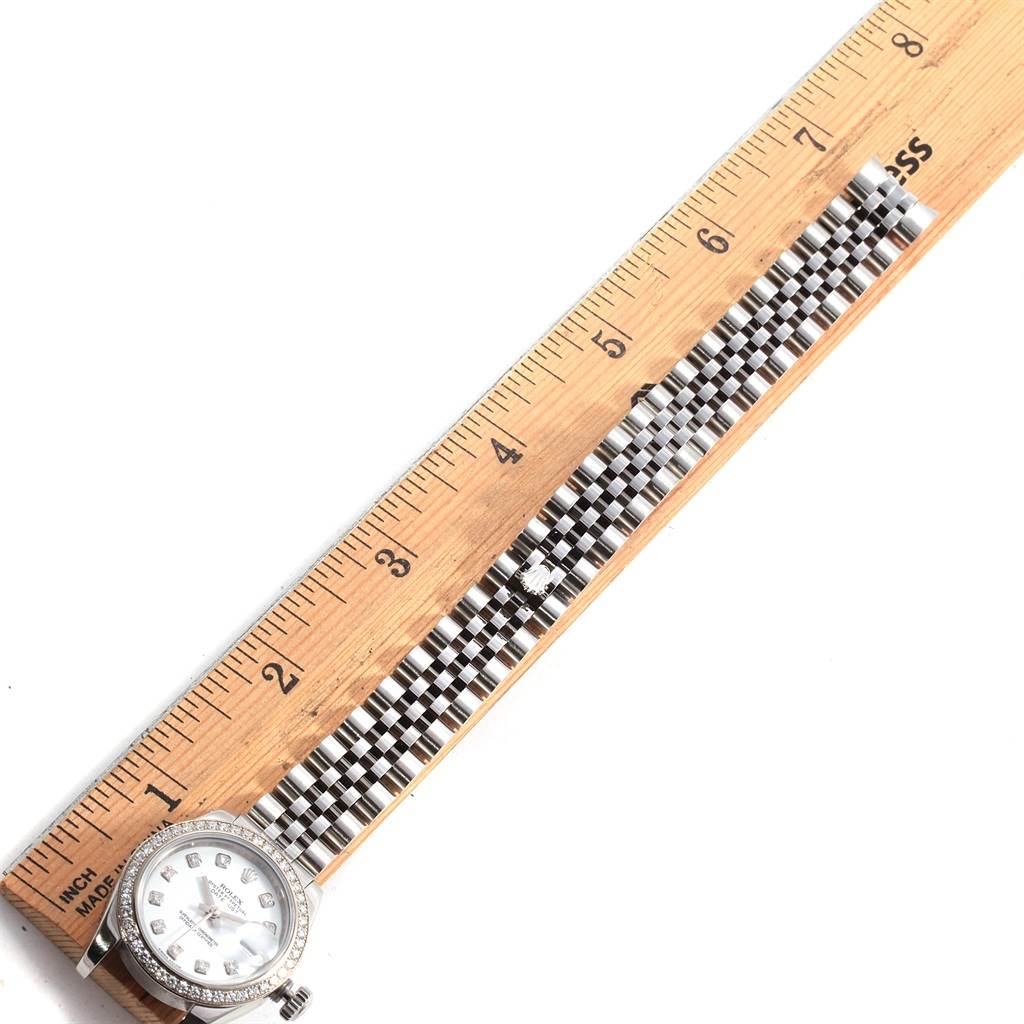 This image shows the Rolex Datejust 179384 Women's Stainless Steel White Dial 179384 Women's Stainless Steel White Dial watch horizontally aligned with a ruler, highlighting its face and bracelet.