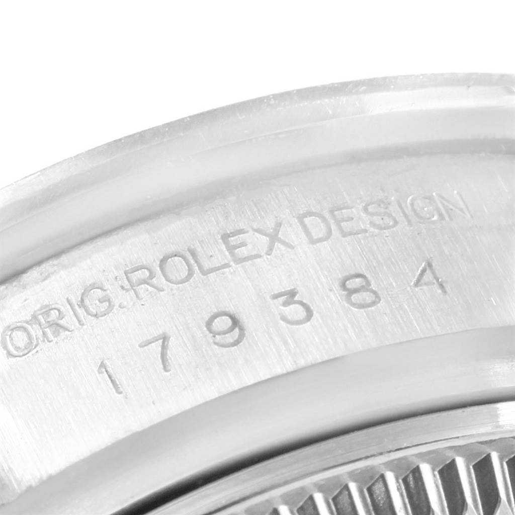 This close-up image shows the engraved serial number and part of the bezel of a Rolex Datejust 179384 Women's Stainless Steel White Dial 179384 Women's Stainless Steel White Dial watch.