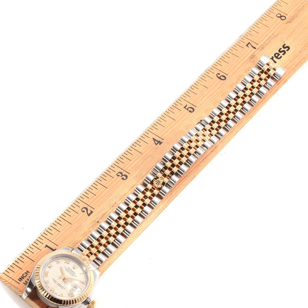 The Rolex Datejust 179173 Women's Steel and Gold (two tone) Beige Dial 179173 Women's Steel and Gold (two tone) Beige Dial watch is shown from a top-down angle, displaying the face and the full length of the bracelet next to a ruler.