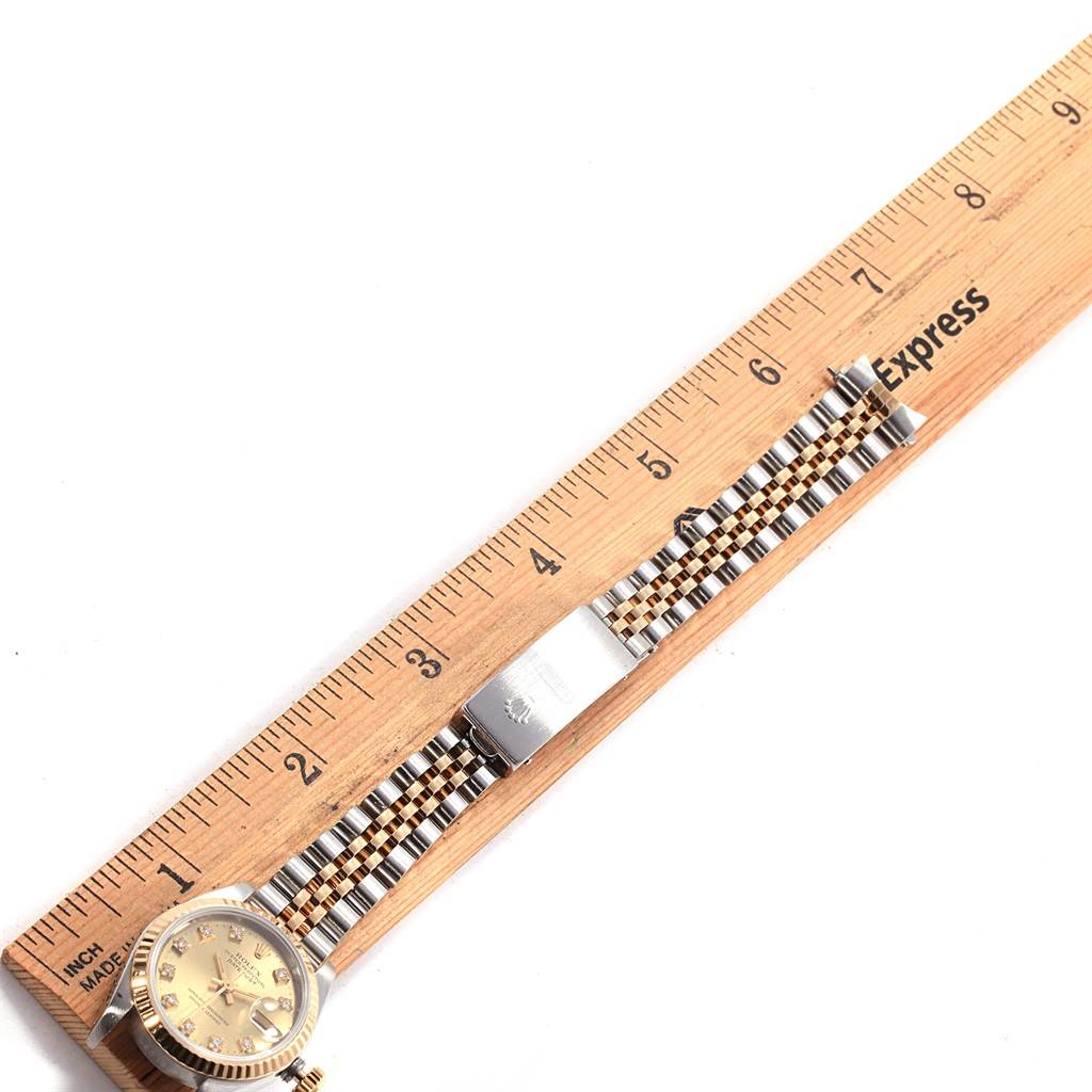 The Rolex Datejust 69173 Women's Stainless Steel Champagne Dial 69173 Women's Stainless Steel Champagne Dial watch is shown at a top-down angle, highlighting its face, bezel, and bracelet beside a ruler for scale.