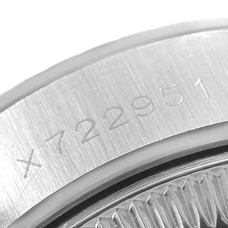 This close-up image of a Rolex Datejust 69174 Women's Stainless Steel Silver Dial 69174 Women's Stainless Steel Silver Dial watch showcases the engraved serial number on its case.