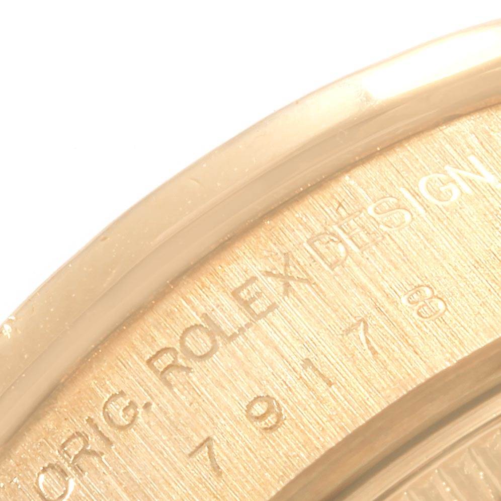 The image shows a close-up of the engraving on the back of a Rolex Datejust 79178 Women's Yellow Gold White Dial 79178 Women's Yellow Gold White Dial watch.