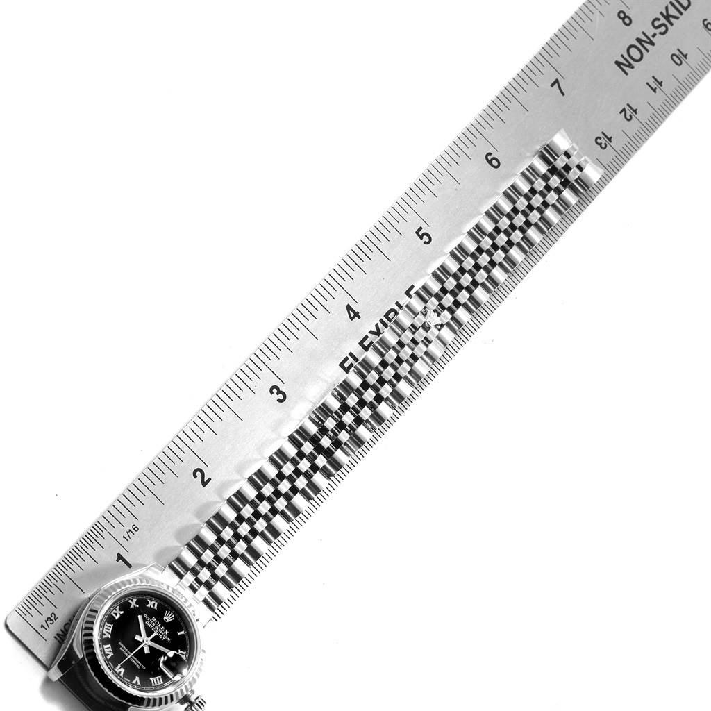 The image shows a Rolex Datejust 179174 Women's Stainless Steel Black Dial 179174 Women's Stainless Steel Black Dial watch, laid flat beside a ruler, displaying the watch face and part of the band.
