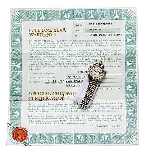 The image shows a Rolex Datejust 79173 Women's Stainless Steel Beige Dial 79173 Women's Stainless Steel Beige Dial watch placed on top of its warranty and certification documents, viewed from above.