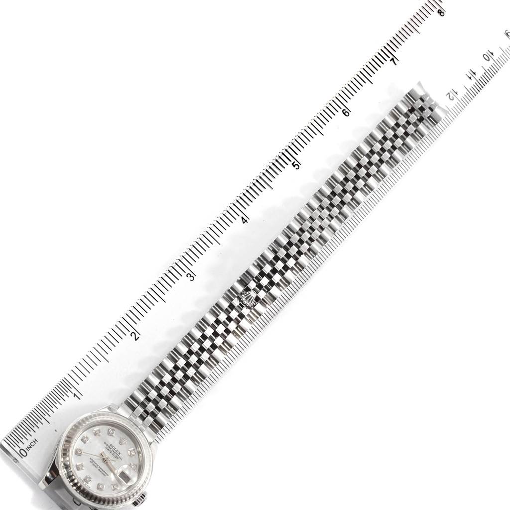 The Rolex Datejust 179174 Women's Stainless Steel Mother of Pearl Dial 179174 Women's Stainless Steel Mother of Pearl Dial watch is shown with its bracelet measured against a ruler at an angled view.