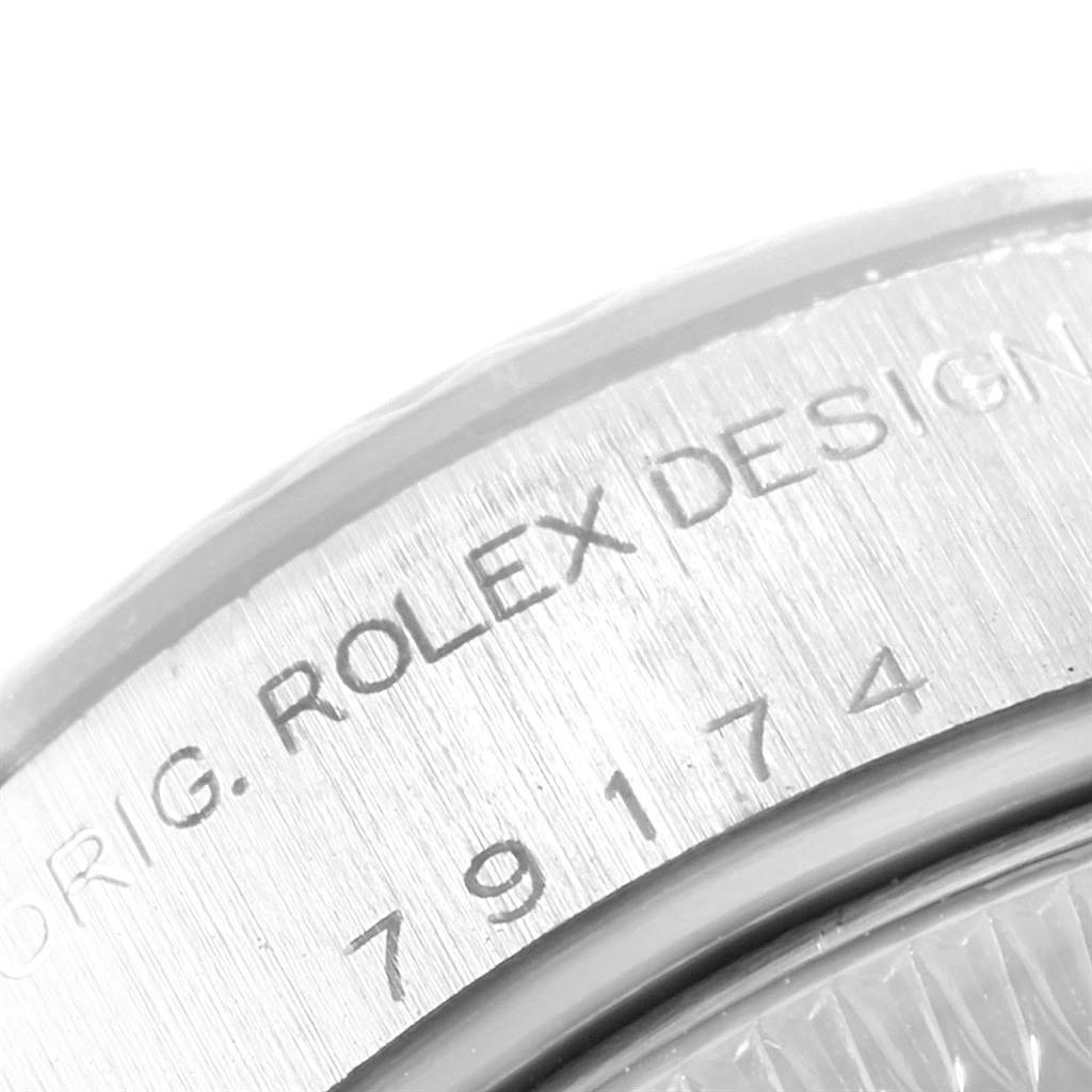 This close-up image shows the engraved text and serial number on the bezel of a Rolex Datejust 79174 Women's Stainless Steel Mother of Pearl Dial 79174 Women's Stainless Steel Mother of Pearl Dial watch.