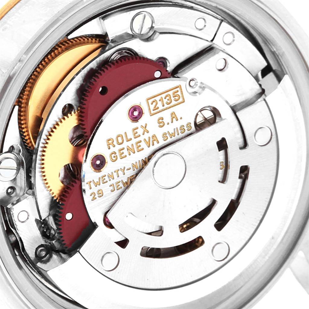 This close-up image shows the intricate mechanical movement of a Rolex Datejust 69173 Women's Stainless Steel Silver Dial 69173 Women's Stainless Steel Silver Dial watch, highlighting the gears and inscriptions.