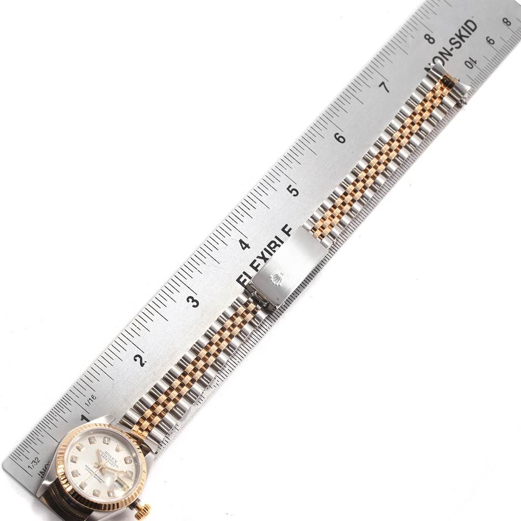 The image shows the Rolex Datejust 69173 Women's Stainless Steel Silver Dial 69173 Women's Stainless Steel Silver Dial watch and its metal bracelet band laid flat next to a ruler.