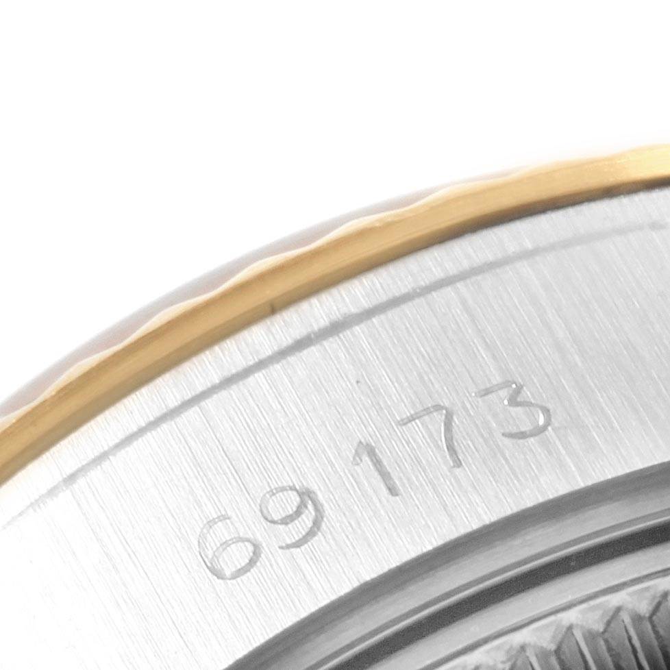 The image shows a close-up of the serial number engraving on the bezel and caseback of a Rolex Datejust 69173 Women's Stainless Steel Black Dial 69173 Women's Stainless Steel Black Dial watch.