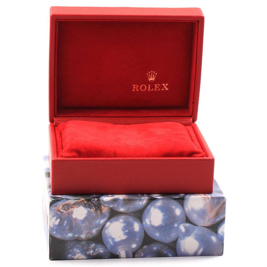 The image shows an empty red Rolex box for the Datejust model, featuring a cushion and the brand logo.