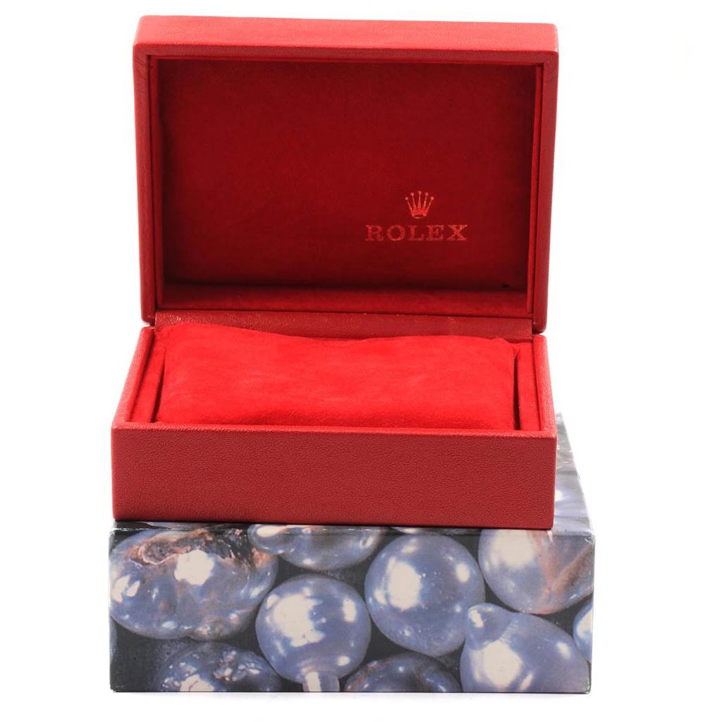 The image shows an open red Rolex Datejust 69173 Women's Stainless Steel Black Dial 69173 Women's Stainless Steel Black Dial watch box with the Rolex logo inside the lid, on top of a decorative box.