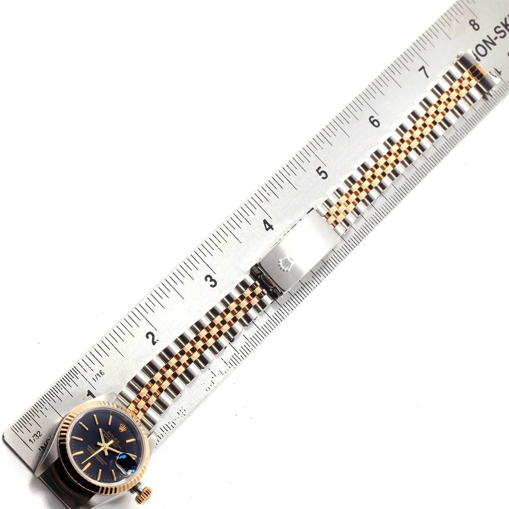 The image shows a Rolex Datejust 69173 Women's Stainless Steel Black Dial 69173 Women's Stainless Steel Black Dial watch with its bracelet and clasp placed next to a ruler.