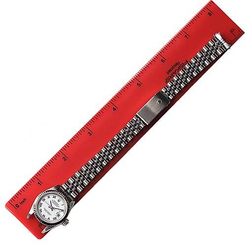 The image shows a side view of a Rolex Datejust 79174 Women
s Stainless Steel White Dial 79174 Women
s Stainless Steel White Dial model watch, highlighting its face, bracelet, and clasp, next to a red ruler.