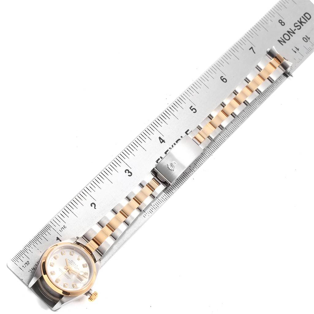 The Rolex Datejust 79163 Women's Steel and Gold (two tone) Silver Dial 79163 Women's Steel and Gold (two tone) Silver Dial watch is shown from an aerial angle, displaying the face and two-tone bracelet next to a ruler.