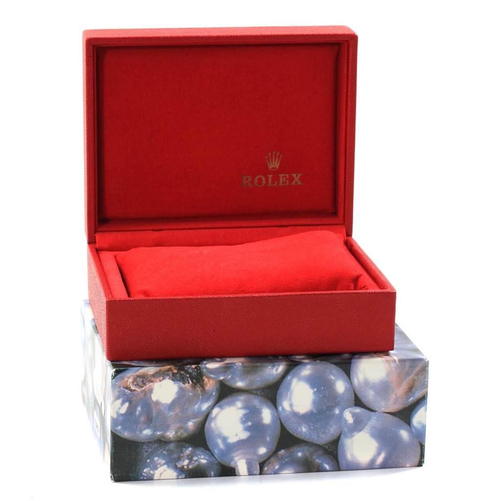 This image shows a red open Rolex Datejust 69173 Women's Stainless Steel Beige Dial 69173 Women's Stainless Steel Beige Dial watch box with a cushion inside, placed on another box with a pearl design.