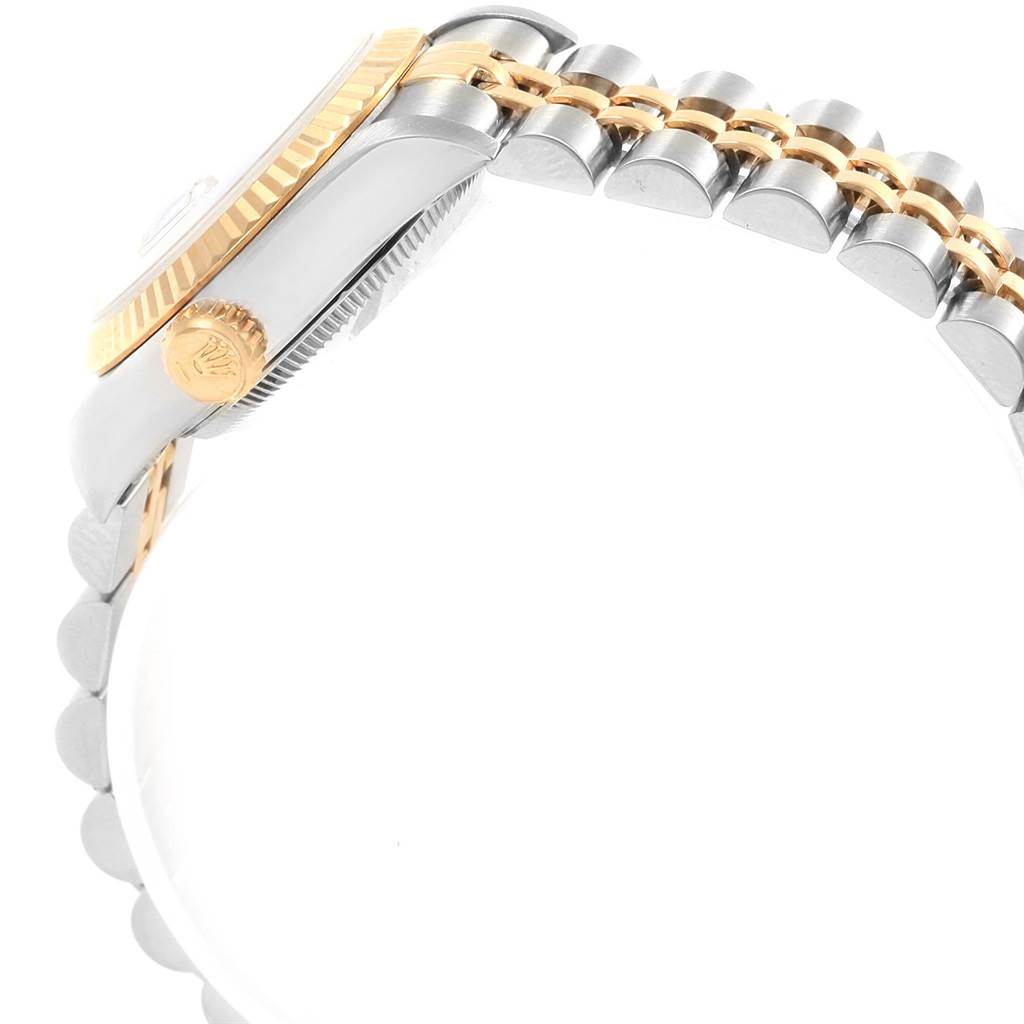 The image shows a side angle of a Rolex Datejust 69173 Women's Stainless Steel White Dial 69173 Women's Stainless Steel White Dial watch featuring its crown, fluted bezel, and two-tone bracelet.