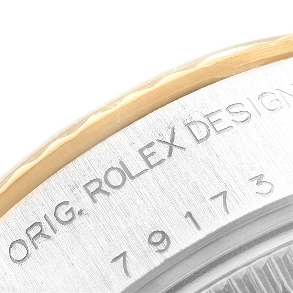 This close-up shot of the Rolex Datejust 79173 Women's Steel and Gold (two tone) Beige Dial 79173 Women's Steel and Gold (two tone) Beige Dial watch shows the engraved text and part of the bezel and case side.