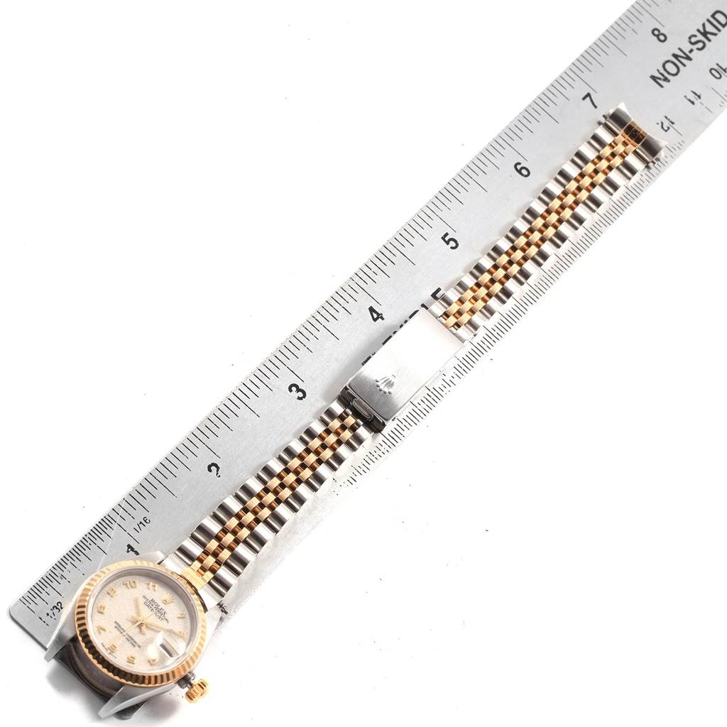 The image shows a Rolex Datejust 79173 Women's Steel and Gold (two tone) Beige Dial 79173 Women's Steel and Gold (two tone) Beige Dial watch horizontally, displaying the face and the two-tone bracelet against a ruler.